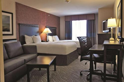 爱德蒙埃特德蒙拉昆塔套房酒店的酒店客房设有一张大床和一张沙发。