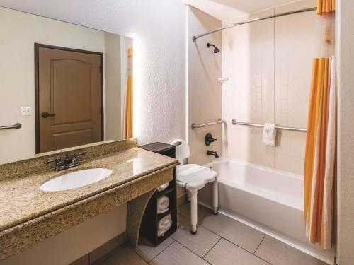 大草原城拉金塔达拉斯大草原城套房酒店的一间带水槽、浴缸和卫生间的浴室