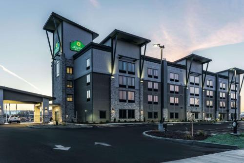 瓦拉瓦拉La Quinta Inn & Suites by Wyndham Walla Walla的一座大建筑,上面有绿色的标志