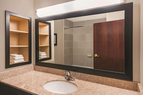普兰菲尔德拉金塔旅馆及套房酒店诺威奇-普兰菲尔德-赌场区店的一间带水槽和大镜子的浴室