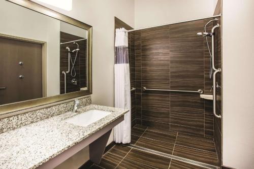 伍德伯里圣保罗伍德伯拉金塔旅馆及套房的带淋浴、盥洗盆和镜子的浴室
