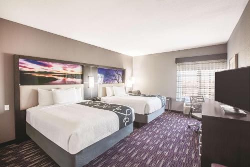 金斯维尔La Quinta by Wyndham Kingsville的酒店客房设有两张床和一台平面电视。