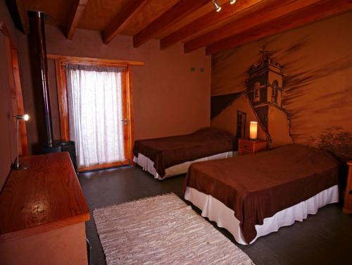 圣佩德罗·德·阿塔卡马Terra Luna Atacama的酒店客房设有两张床和窗户。