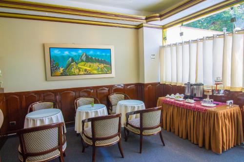 利马雷克萨斯酒店的餐厅设有桌椅,墙上挂有绘画作品