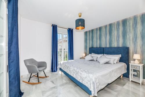 马贝拉Luxury Townhouse Golden Mile的一间卧室配有蓝色的床和椅子