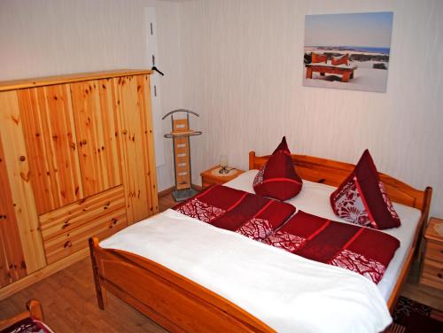 克洛斯特Ferienwohnungen Insel Hiddensee RU的一间卧室配有一张带红色枕头的床