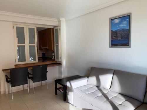 圣地亚哥港El Teide的一间带白色沙发的客厅和一间厨房