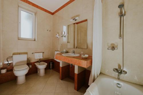 蒂米什瓦拉雷斯登塞酒店的浴室配有卫生间、盥洗盆和浴缸。