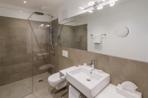 努齐德斯德纽酒店的一间带水槽、淋浴和卫生间的浴室