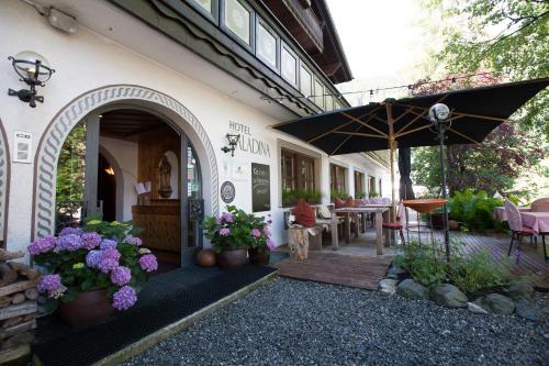 加舒恩萨拉蒂娜生态酒店的户外庭院配有遮阳伞和桌椅。
