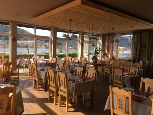 热拉梅Le Ptit Hotel du Lac的用餐室设有桌椅和窗户。