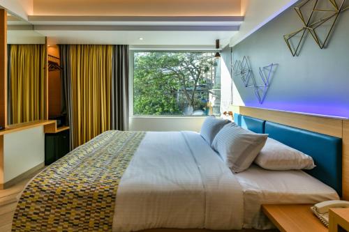 孟买Indie Stays的一间卧室设有一张大床和一个窗户。