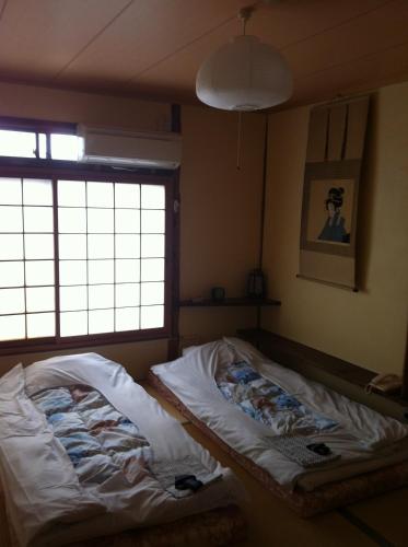 京都洛顶旅馆的带窗户的客房内的两张床
