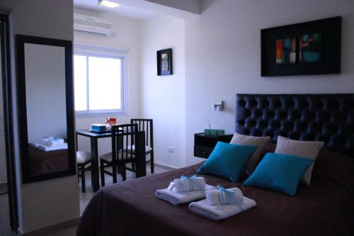 科尔多瓦Villa Cabrera Apart and Suites的一间卧室配有一张床,上面有两条毛巾