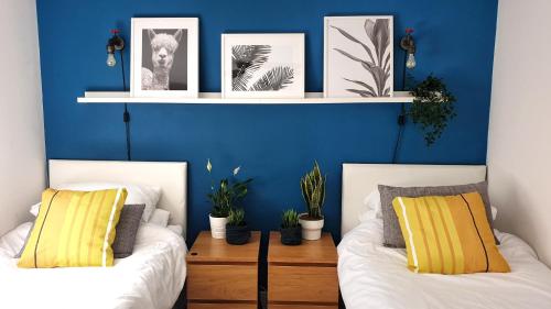 伦敦家外之家精品公寓的蓝色墙壁客房的两张床
