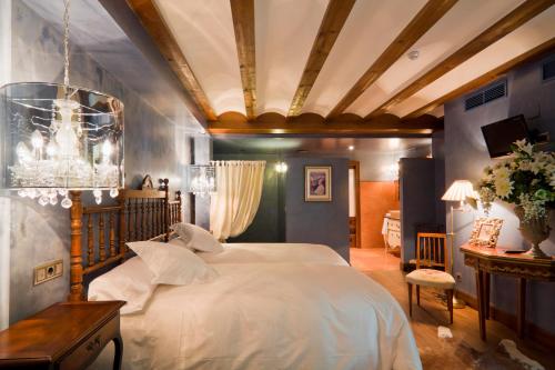 拉瓜迪亚洛斯帕拉赫斯酒店的卧室配有一张白色大床和吊灯。