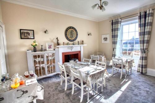 威格敦Craigmount的一间带桌椅和壁炉的用餐室