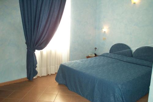 皮特拉利古Hotel La Milanese的一间卧室设有蓝色的床和窗户。