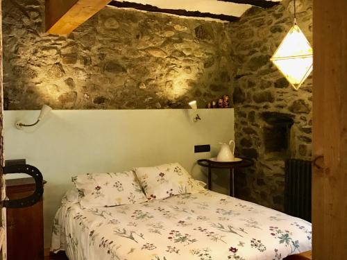 AncilesCasa Mingot SXVI Anciles Benasque的卧室配有一张石墙床