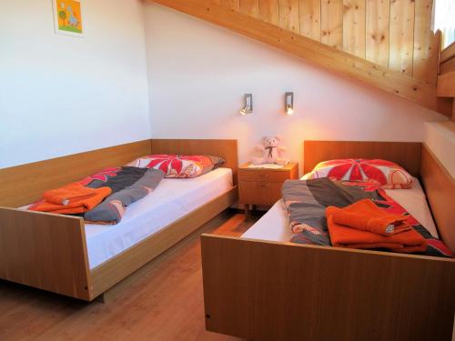 马兰扎Rosenheim的铺有木地板的客房内的两张床