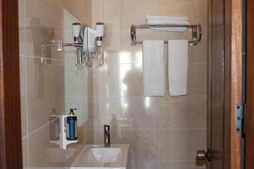 米尔芳提斯城Guest House - Duna Parque Group的浴室配有盥洗盆、镜子和毛巾