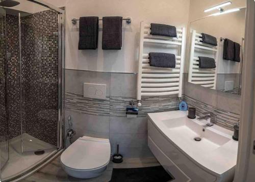 卡莫利Portofino House的浴室配有卫生间、盥洗盆和淋浴。