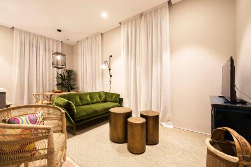 格拉纳达U-Sense Granada Catedral的客厅配有绿色沙发和凳子