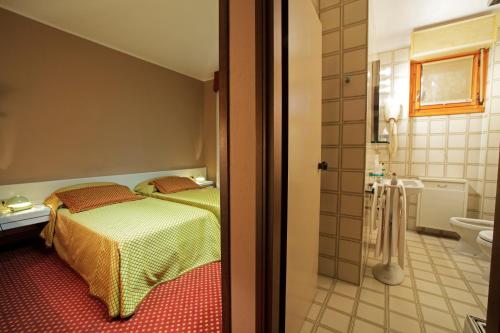 Garlasco迪亚曼蒂I酒店的一间卧室设有一张床和一间浴室。
