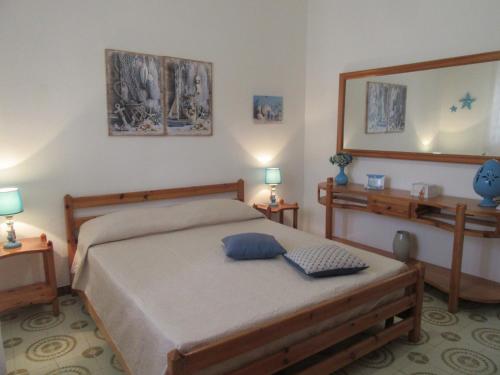 普罗斯西托角Villa Oltremare的一间卧室配有一张带两盏灯和镜子的床
