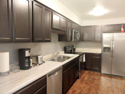 罗利Inviting Condo in Central Raleigh的厨房配有木制橱柜和不锈钢冰箱。