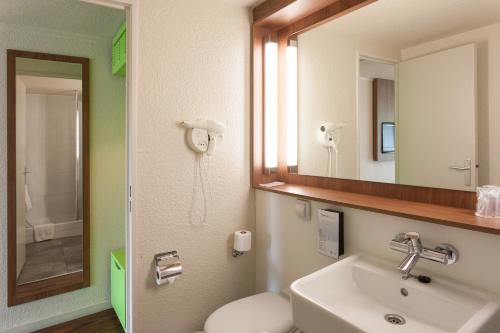 普瓦捷普瓦捷钟楼酒店的一间带水槽、镜子和卫生间的浴室