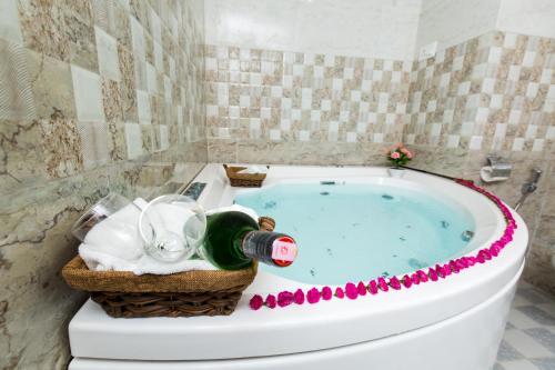 奇旺Hotel Earth Light Sauraha的带浴缸和一瓶香槟的浴室