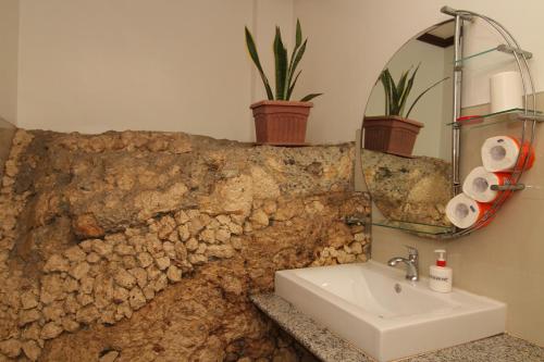 长滩岛绿色庭院酒店的一间带水槽和石墙的浴室