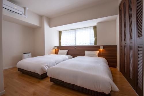 名户Lieta Nakayama的一间卧室设有两张床和窗户。