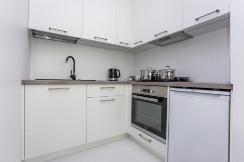 比亚韦斯托克CR Kameralny Apartament przy Pałacu Branickich的厨房配有白色橱柜和不锈钢用具