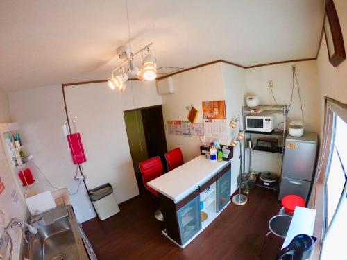 京都Benidaruma - Sakuramochi的一个带书桌和红色椅子的小厨房