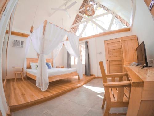 锡基霍尔Bermuda Triangle Bungalows的一间卧室配有一张带窗户的床和一张书桌