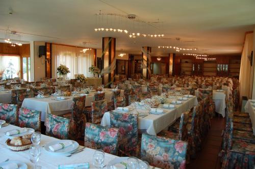 Cotroneihotel lo sciatore的宴会厅配有白色的桌椅