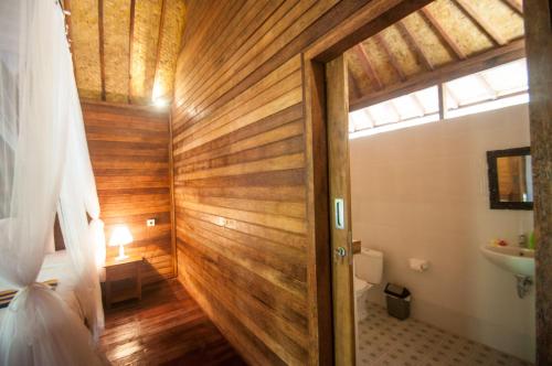 珀尼达岛Ruji Ananta Cottage的一间带木墙和门的浴室
