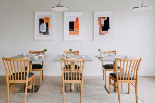 库克斯港米尔泽特酒店的用餐室配有桌椅和壁画