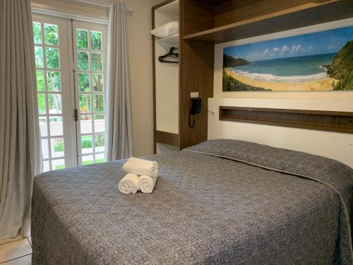 弗洛里亚诺波利斯圣塞巴斯蒂昂普拉亚酒店的一间卧室配有一张床,上面有两条毛巾