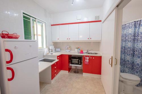 拉克鲁斯Casa Maria的厨房配有红色和白色的橱柜和卫生间