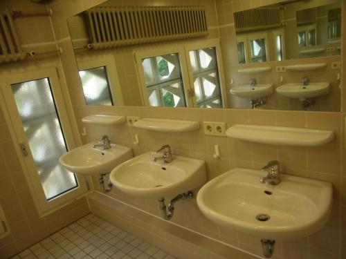 柏林圣-米赫尔斯-黑姆青年旅社的一间带三个水槽和镜子的浴室