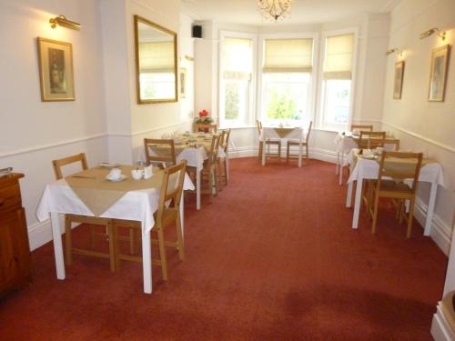 伯恩茅斯Southernhay Guest House的用餐室设有桌椅和窗户。