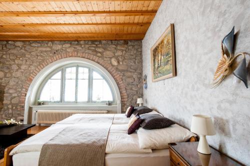 马里勒格兰德相思酒店的一间卧室设有一张大床和石墙