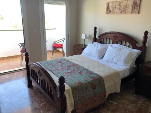 托雷德尔马尔Casa de la Colina的一间卧室配有一张木架大床