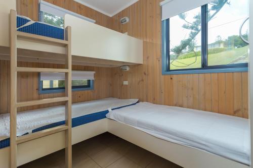 图洛斯海德Tuross Beach Cabins & Campsites的带窗户的客房内的两张双层床