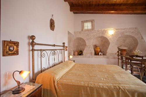 阿尔贝罗贝洛萨利塔德尔皮尔住宿加早餐乡村民宿的一间带一张床铺的卧室,位于带拱门的房间