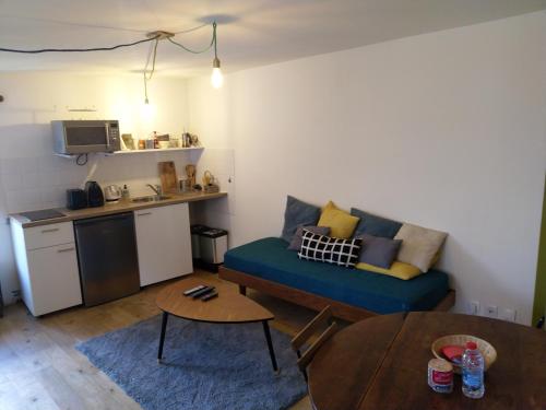 绍维尼Tour Duguesclin的一间带蓝色沙发的客厅和一间厨房
