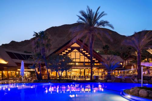 埃拉特Orchid Eilat Hotel的夜间带游泳池的度假村